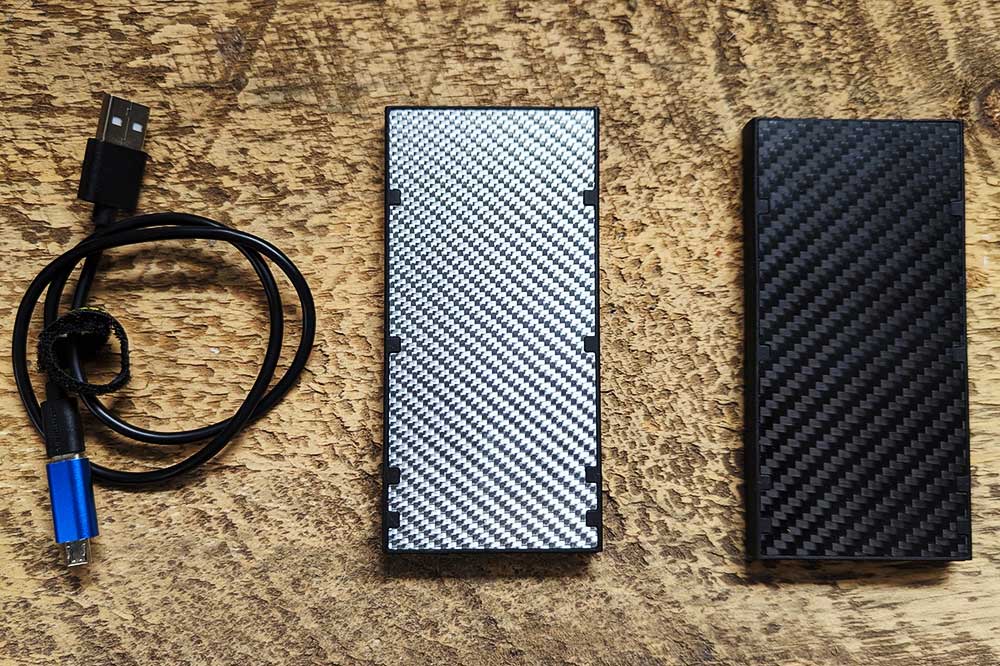 two power banks and a cord on a wooden surface