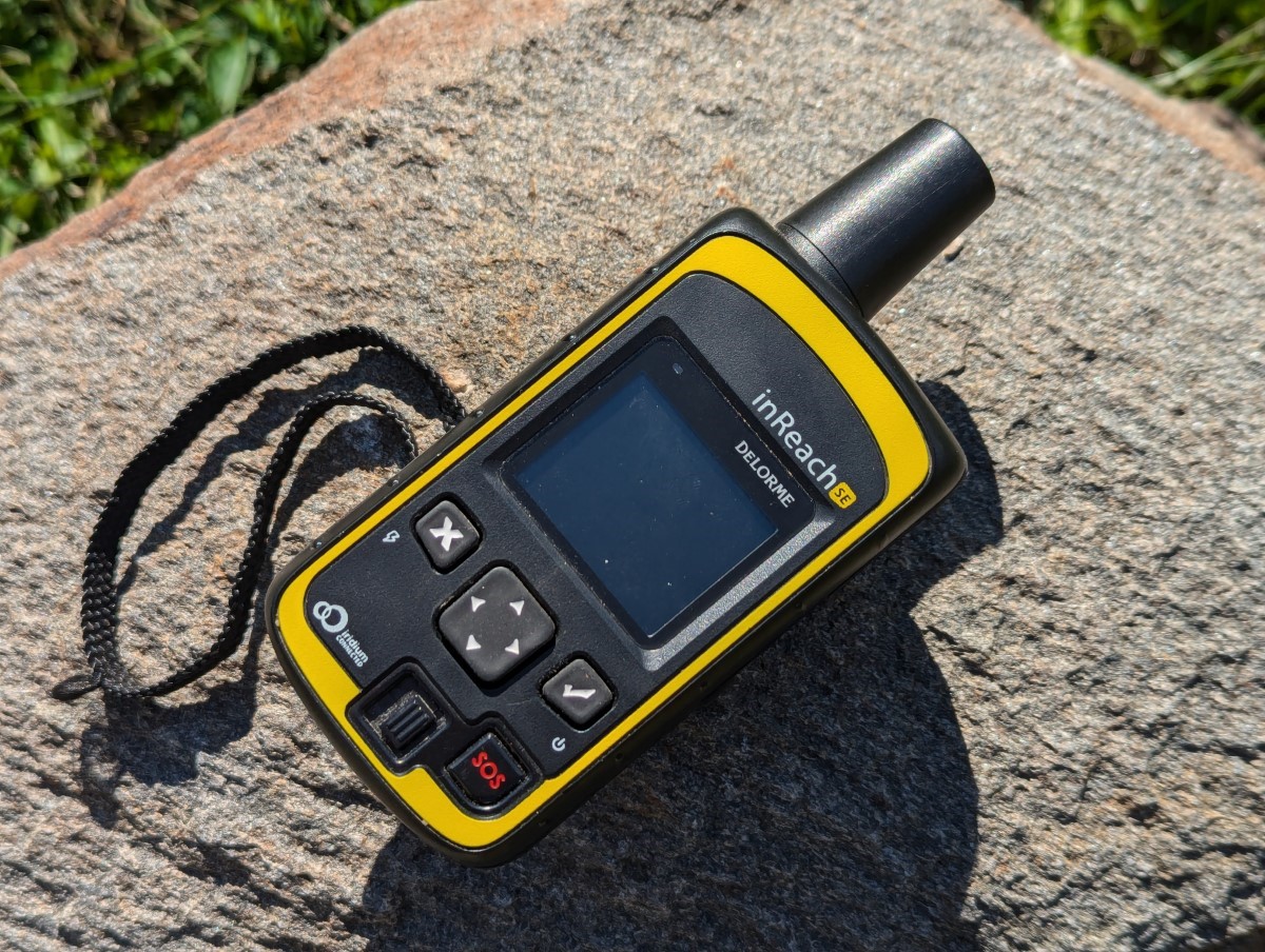 A Garmin inReach sitting on a rock.